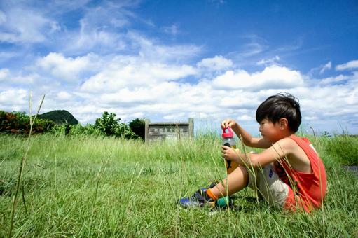 <Material> A boy drinking tea from a water bottle while playing in the park, JPG <Material> A boy drinking tea from a water bottle while playing in the park, JPG