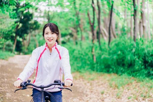 自然の中でサイクリングを楽しむ若い女性 電動サイクル,旅,若いの写真素材