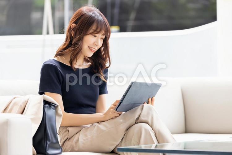 ソファでタブレットを使うビジネスウーマン 女性,ビジネス,タブレットの写真素材