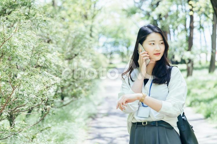 新緑の街中に立つキャリアウーマン ビジネス,女性,ビジネスウーマンの写真素材