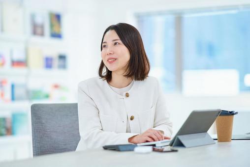 和やかな雰囲気の中で仕事をする女性 和やかな雰囲気の中で仕事をする女性 パソコン,笑顔,オフィスシーンの写真素材