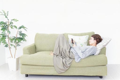 寝転んでスマホを使う女性 休日,ライフスタイル,社会人の写真素材