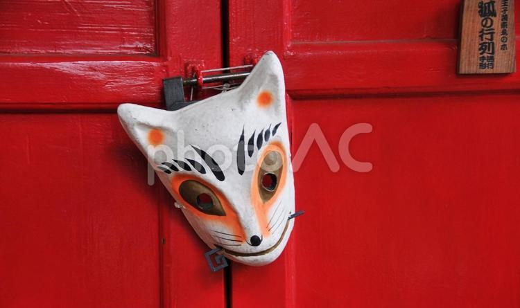 朱色の扉にかけられた狐のお面 狐の面,お稲荷さん,狐の写真素材