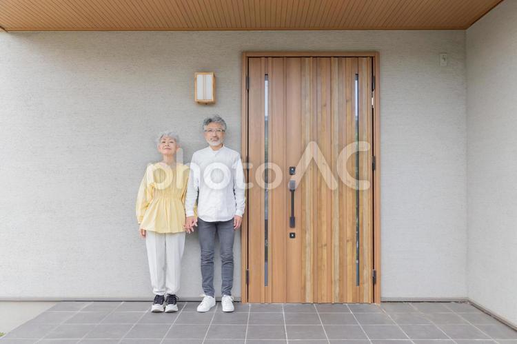 笑顔で住宅の前に立つシニアカップル シニア,老人ホーム,カップルの写真素材