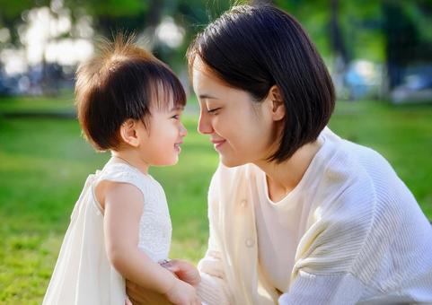 緑の中で遊ぶ、子と母親 緑の中で遊ぶ、子と母親の写真