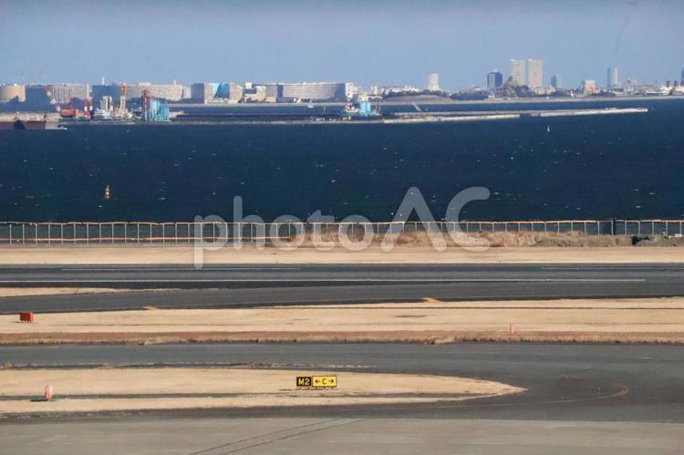 滑走路と青い海と湾岸の街とビル群の街並み 滑走路,青い,海の写真素材