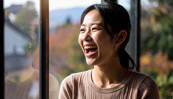 口を大きく開けて笑う女性。歯科の素材用の写真