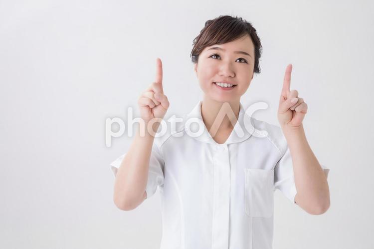 指差す白衣の女性 こちら,笑顔,女性の写真素材
