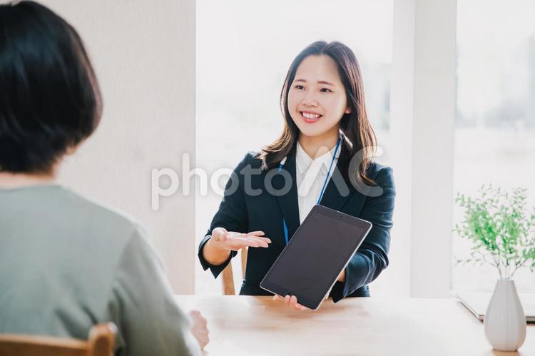 タブレットでお客様に案内する営業マン タブレット,働く女性,ビジネス女性の写真素材