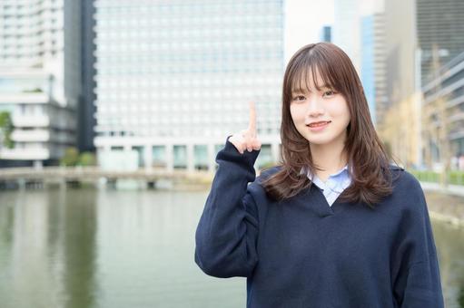 ビル街で指をさす女子高生 ビル街で指をさす女子高生 高校生,女子高生,指さしの写真素材