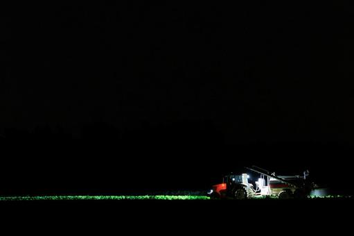 夜に作業するトラクター 夜に作業するトラクターの写真