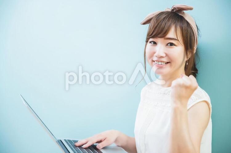 【ガッツポーズ】パソコンを使ってリモートワークをする女性 テレワーク,リモートワーク,副業の写真素材