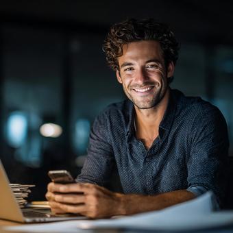 笑顔でスマホを持つ若手起業家 笑顔でスマホを持つ若手起業家の写真