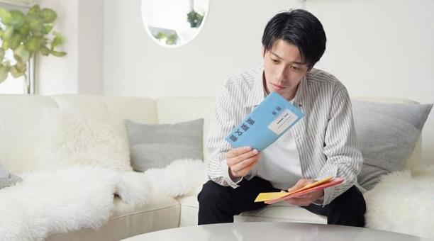督促状を確認するアジア人男性 督促状,催促,封筒の写真素材