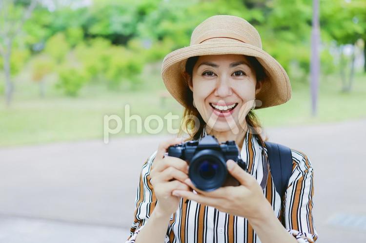 カメラを持って微笑む女性 カメラ,一眼レフ,一眼レフカメラの写真素材