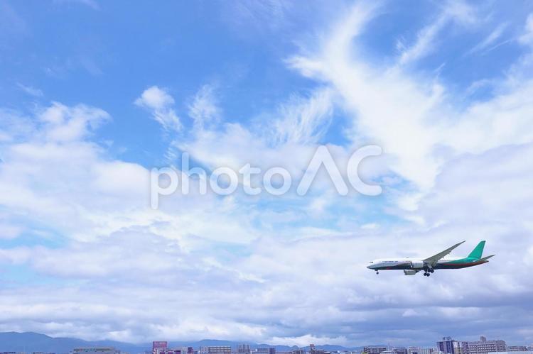 空と着陸する飛行機と街並み 空,青空,飛行機の写真素材