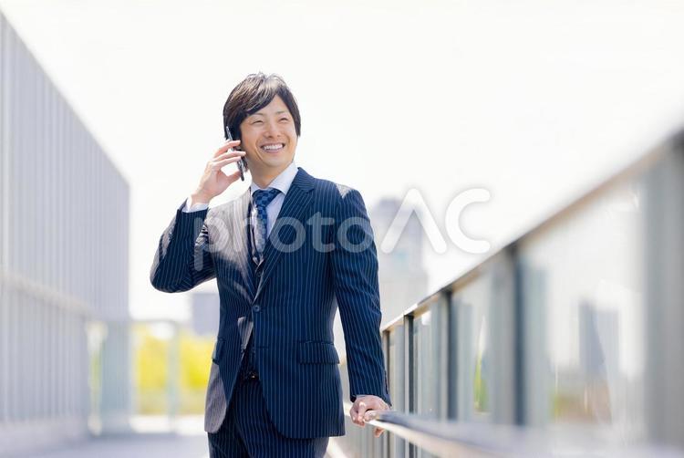 スマホで通話をするスーツの男性 ビジネスマン,ビジネス,男性の写真素材