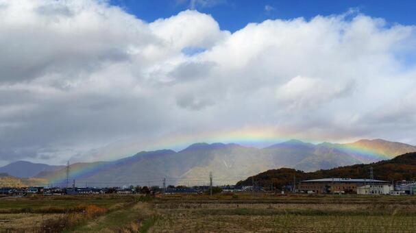 紅葉の山と街に虹がかかる幻想的な風景 虹,レインボー,街の写真素材