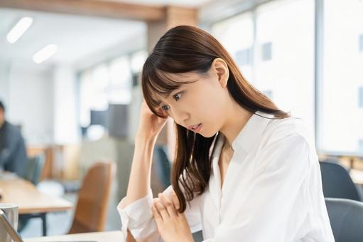 パソコンを使いながら困る女性 パソコンを使いながら困る女性 女性,パソコン,考えるの写真素材