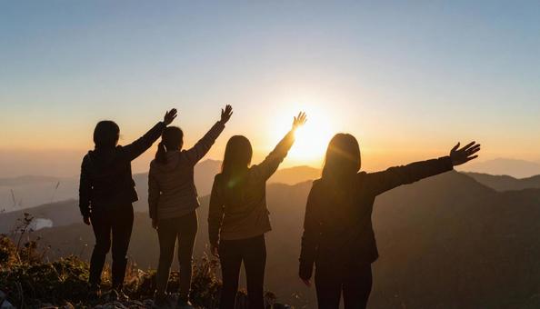 夏山で朝日に向かって手をあげる登山者 夏山で朝日に向かって手をあげる登山者の写真
