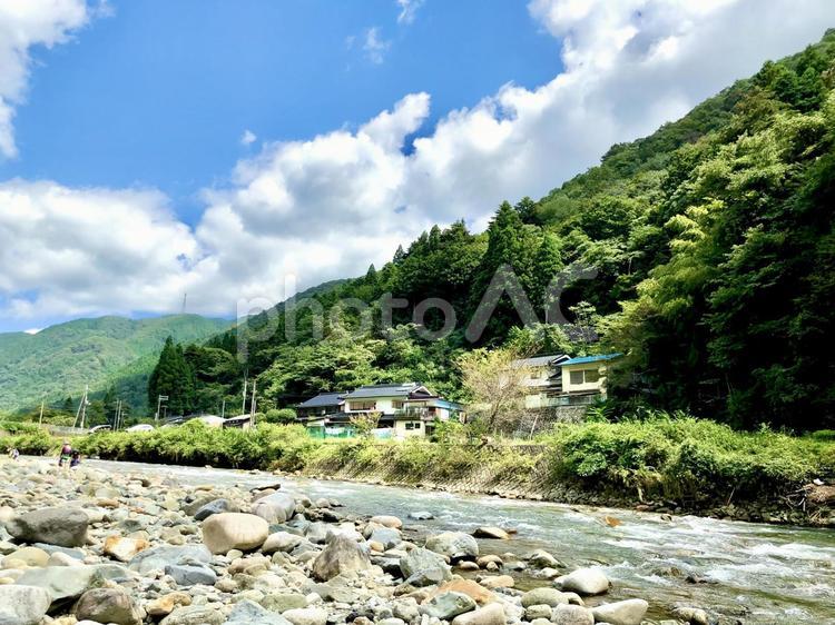 川のせせらぎから山と青空と民家 山,川,青空の写真素材