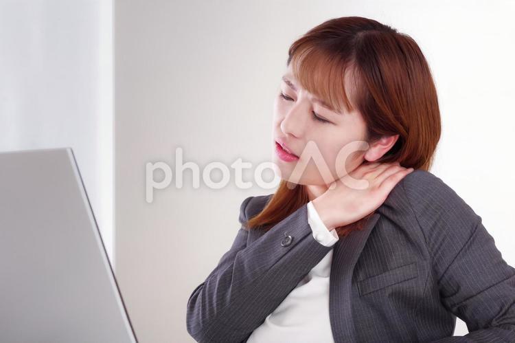 肩が痛そうに手を当てている女性 肩こり,寝違え,寝違えるの写真素材