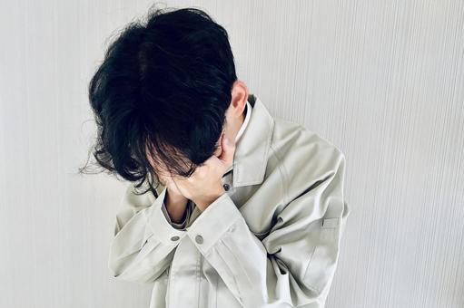 落ち込む男性作業員 落ち込む,ミス,ショックの写真素材