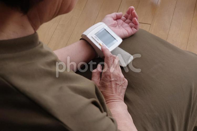 手首式血圧計で血圧を測る年配・高齢女性1 血圧,年配,女性の写真素材