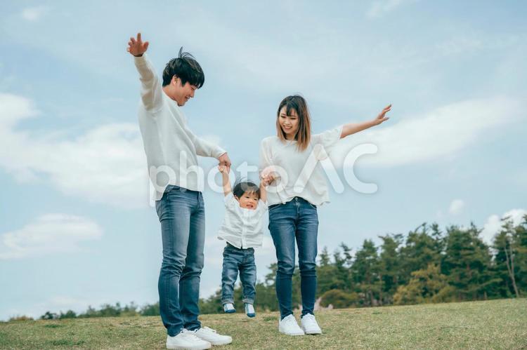 空と家族・ファミリー・赤ちゃん（バンザイ・ジャンプ） 家族,子供,夫婦の写真素材