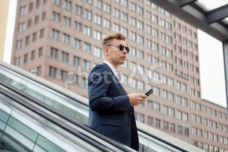 屋外のエスカレーターに乗るビジネスマン7 ビジネスマン,男性,外国人の写真素材
