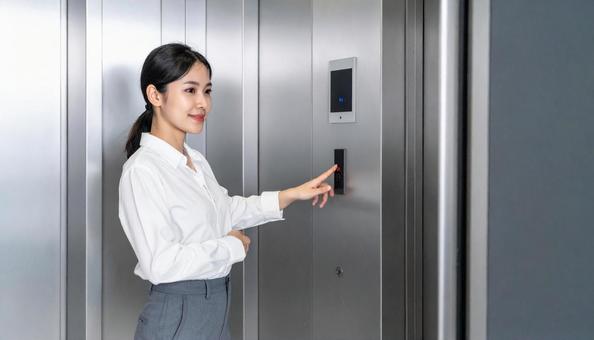 エレベーターを使う若いビジネスウーマン エレベーターを使う若いビジネスウーマンの写真