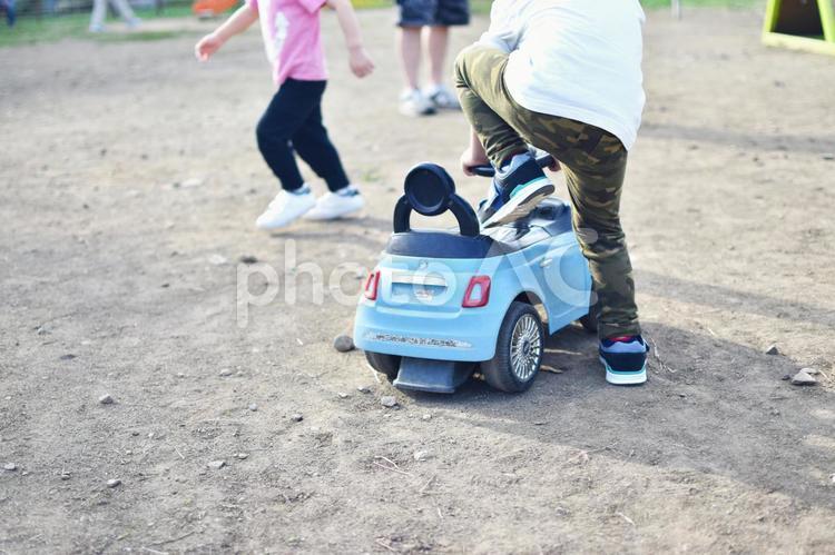 おもちゃの車に乗ろうとする子供 車,乗り物,おもちゃの写真素材
