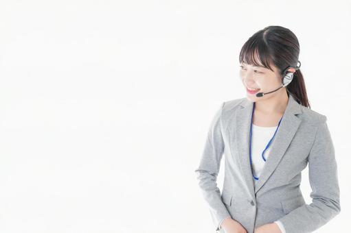 笑顔で対応をするコールセンターの女性 コピースペース,イヤホン,案内の写真素材