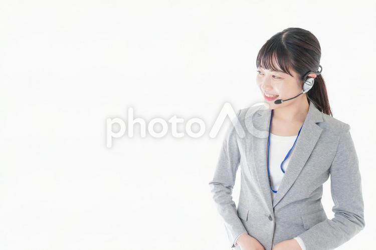 笑顔で対応をするコールセンターの女性 コピースペース,イヤホン,案内の写真素材