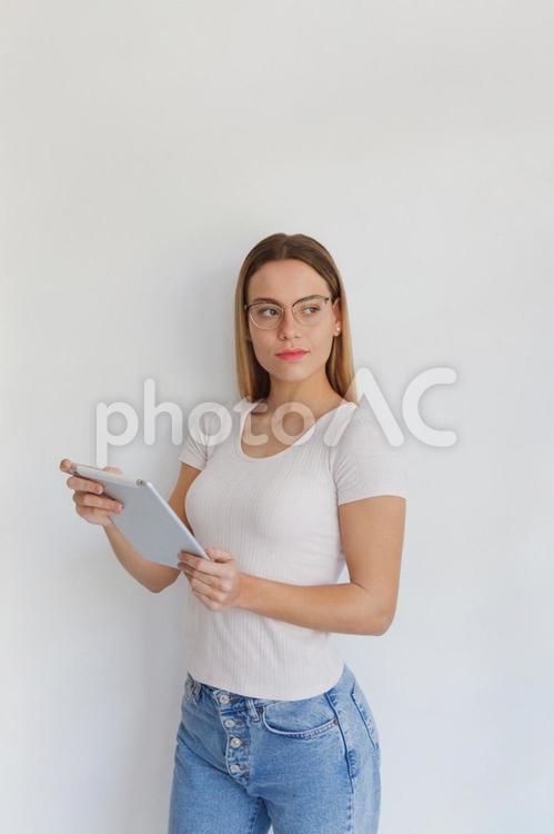 タブレットを持ち横を見る女性 女性,タブレット,持つの写真素材