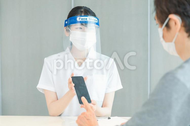 スマホで体温を測る白衣の女性と患者 体温計,病院,検温の写真素材