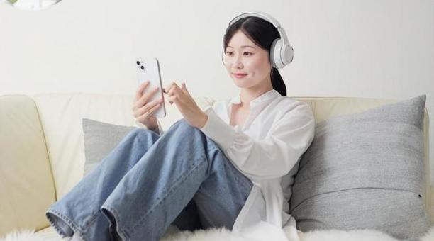 ワイヤレスヘッドフォンで音楽を聞く女性 ワイヤレスヘッドフォンで音楽を聞く女性 女性,ワイヤレス,聴くの写真素材