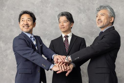 円陣で手を重ねるミドルエイジ男性 円陣で手を重ねるミドルエイジ男性 エグゼクティブ,ビジネスマン,円陣の写真素材