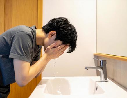 家で洗顔している若い日本人男性 家で洗顔している若い日本人男性の写真