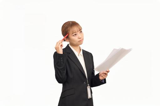 資料を持って悩む女性 資料を持って悩む女性 ビジネスウーマン,若い,屋内の写真素材