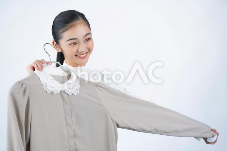 洋服を体に当ててみる女性（白背景） 女性,日本人,１人の写真素材