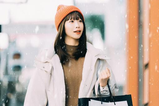 雪が降る冬の街でショッピングをする女性 冬,女性,街の写真素材