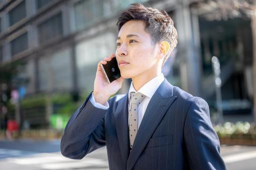 オフィス街で電話するビジネスマン オフィス街で電話するビジネスマン ビジネスマン,営業職,若手社員の写真素材