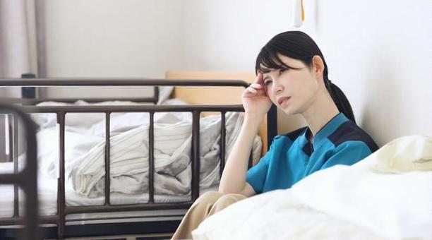 介護の仕事で疲れるアジア人介護士 介護の仕事で疲れるアジア人介護士 介護士,介護福祉士,女性の写真素材