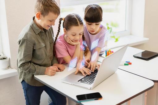 頬杖をついてパソコンを見る生徒たちの写真