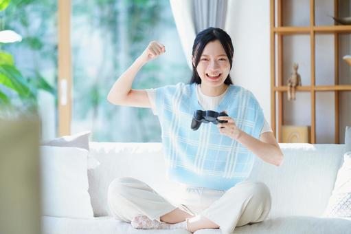 コントローラーを持ちガッツポーズの女性 女性,ガッツポーズ,嬉しいの写真素材
