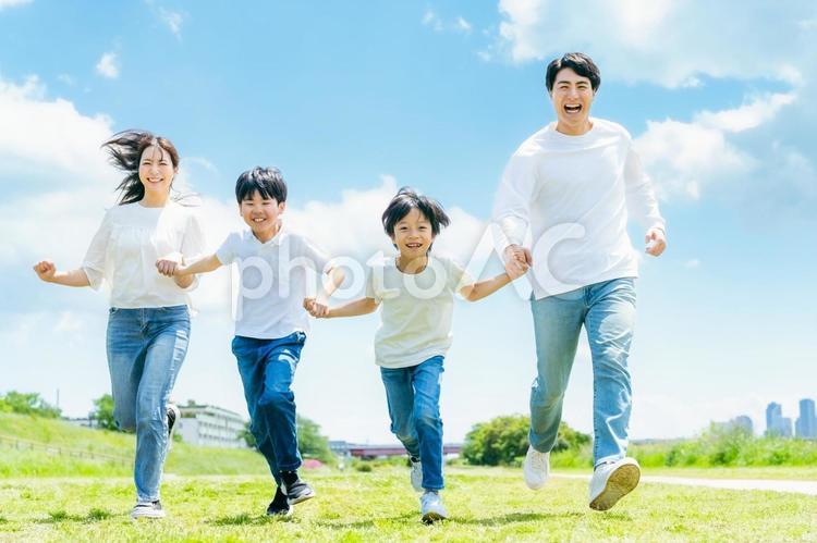 青空の草原を走る家族 家族,笑顔,青空の写真素材