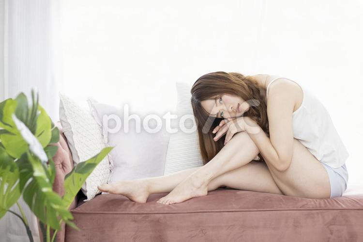 ソファーの上でくつろぐキャミソールの女性 モーニングルーティン,女性,日本人の写真素材