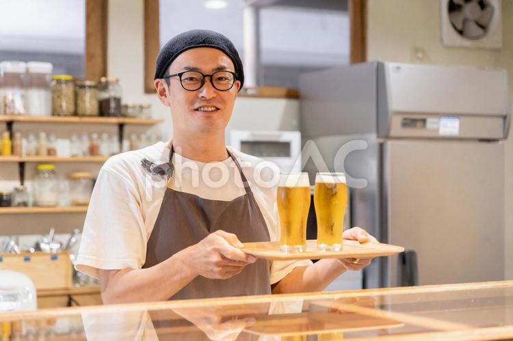 ビールを出す飲食店・居酒屋の男性スタッフ 居酒屋,ビール,バーの写真素材