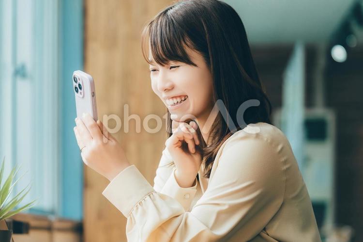 笑顔でスマホを使う女性・ビジネスウーマン 女性,笑顔,スマホの写真素材
